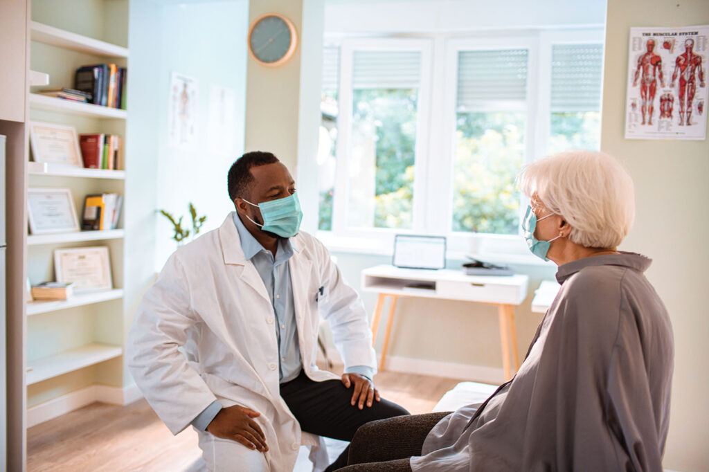 Doctor speaking with patient wearing face masks at Allpria Healthcare in Aurora and Longmont, Colorado